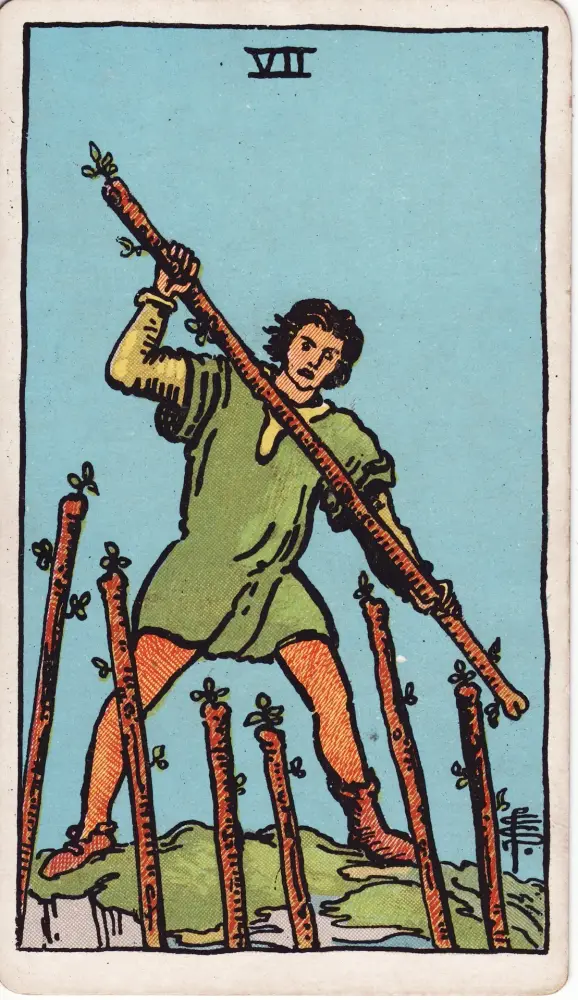 Lá Bảy Gậy trong công việc và tài chính: Lá Bảy Gậy (Seven of Wands) trong bộ Tarot Rider-Waite-Smith, bản in 1909