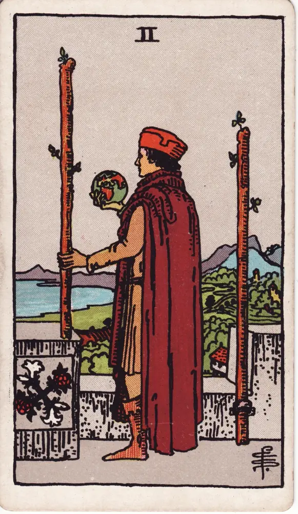 Lá Hai Gậy trong công việc và tài chính: Lá Hai Gậy (Two of Wands) trong bộ Tarot Rider-Waite-Smith, bản in 1909